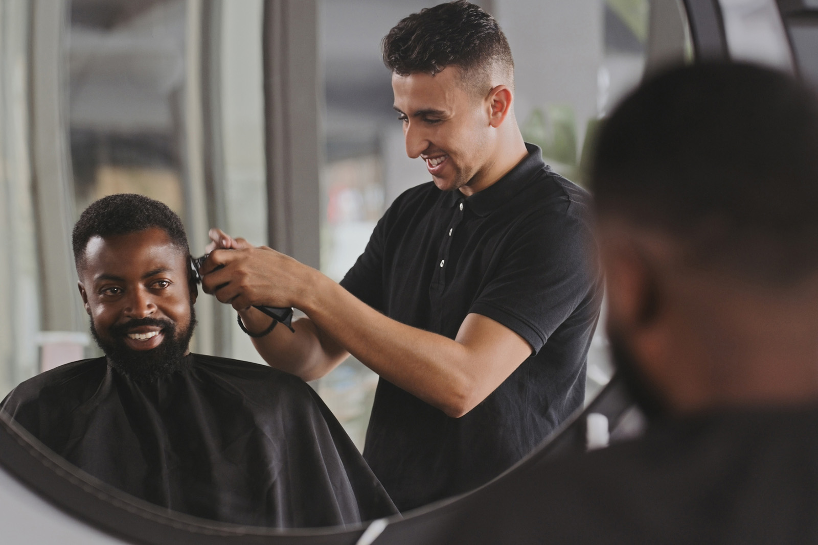 Barber is cutting client's hair