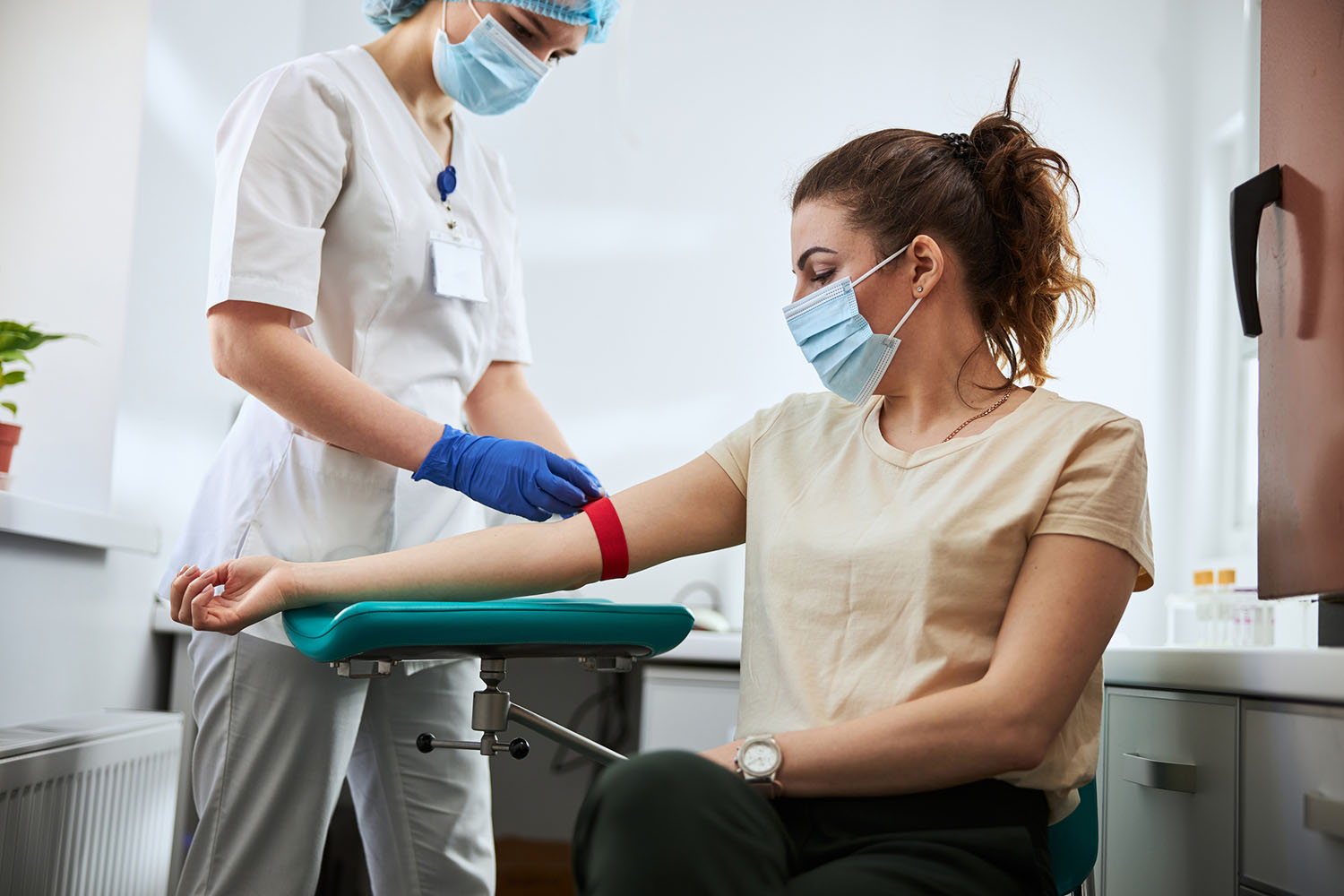 Phlebotomist drawing blood form patient