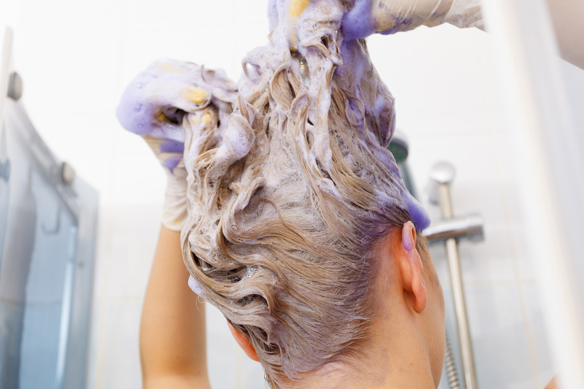 Woman applying purple toner shampoo